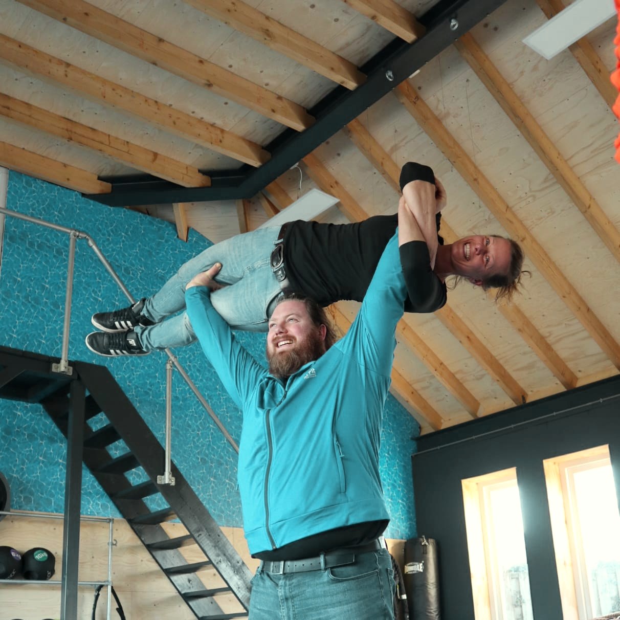 Michael tilt een trainingspartner op in de studio